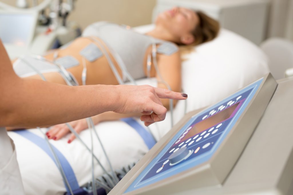 Cosmetologist works with cosmetology medical equipment, twists the lever and presses buttons on the